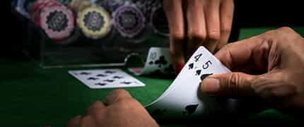 The hand of a croupier dealing out a hand of blackjack.
