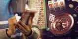 A person holding a mobile phone, with a padlock symbol above it, next to a roulette wheel.