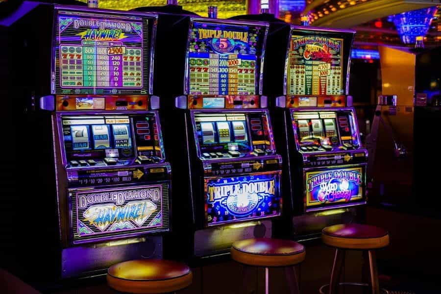 Three slot machines in a row in a casino.