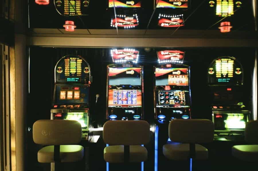 A row of three slot machines inside a casino.