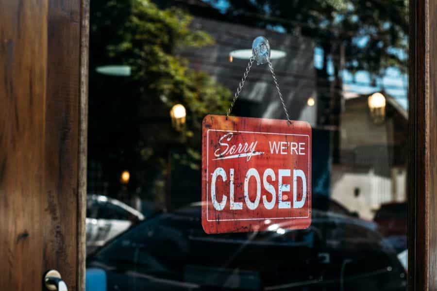 A window with a sign reading Sorry, We Are Closed.