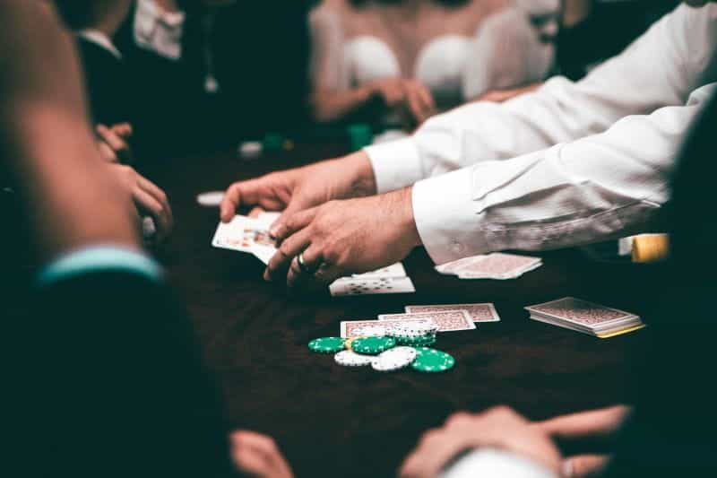 A croupier dealing out cards and chips in a busy casino.