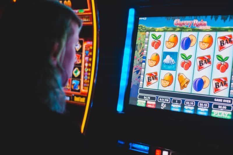 Man looking into a screen with slot games.