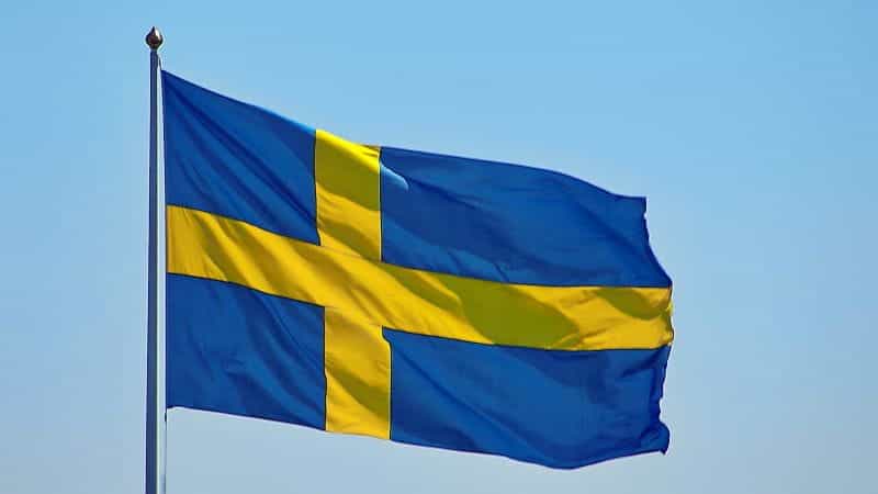 A Sweden flag set against a blue sky backdrop.