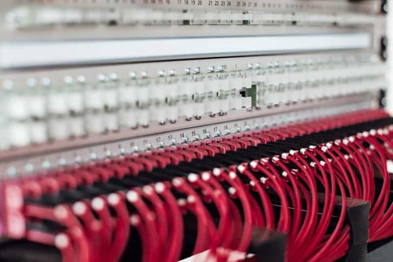 Red colored fiber optic cables going attached to ports.