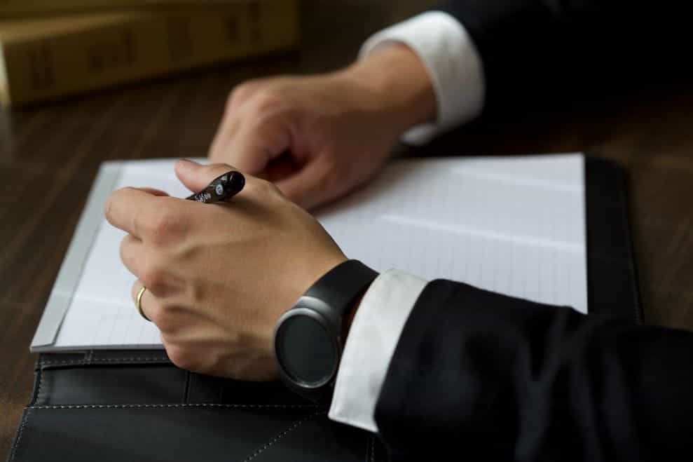 A man in a suit signing a document.