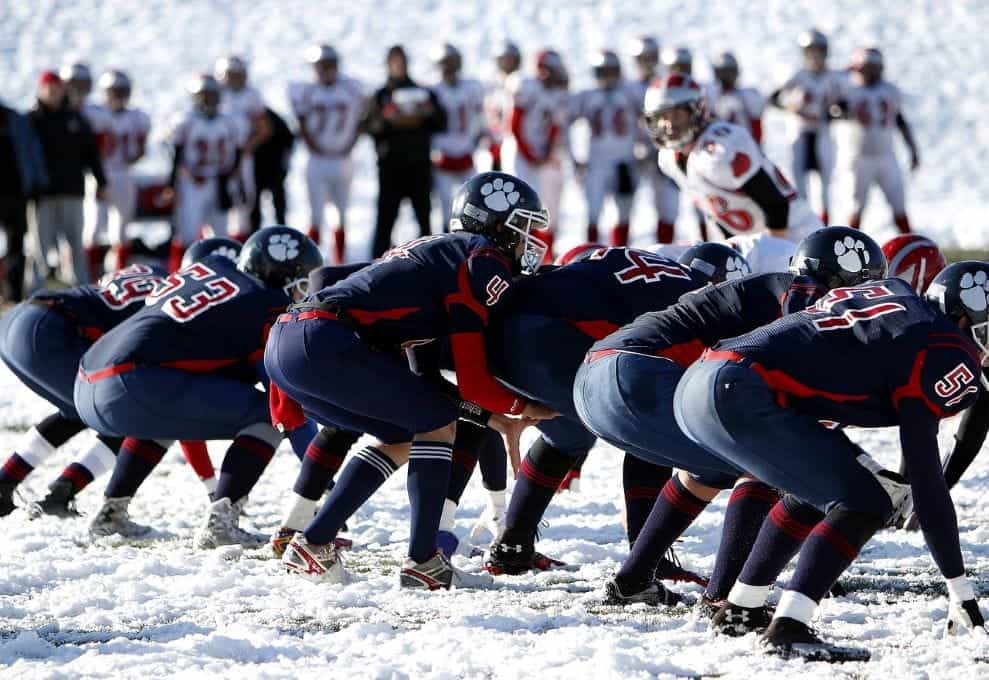 A row of American football players ready.