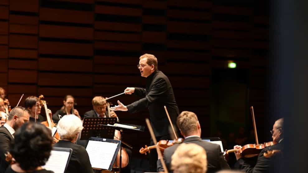 A conductor in front of an orchestra.