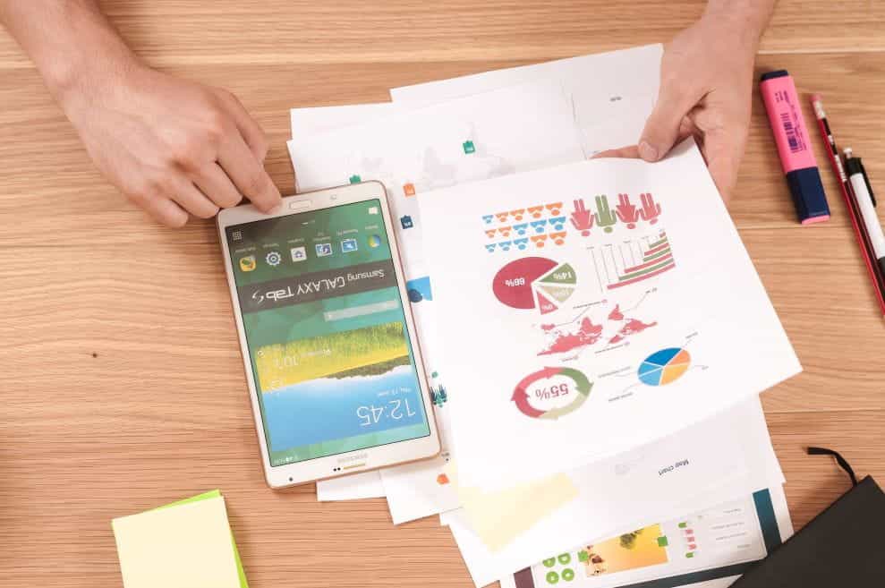 A person analyzes various graphs and data on a desk.