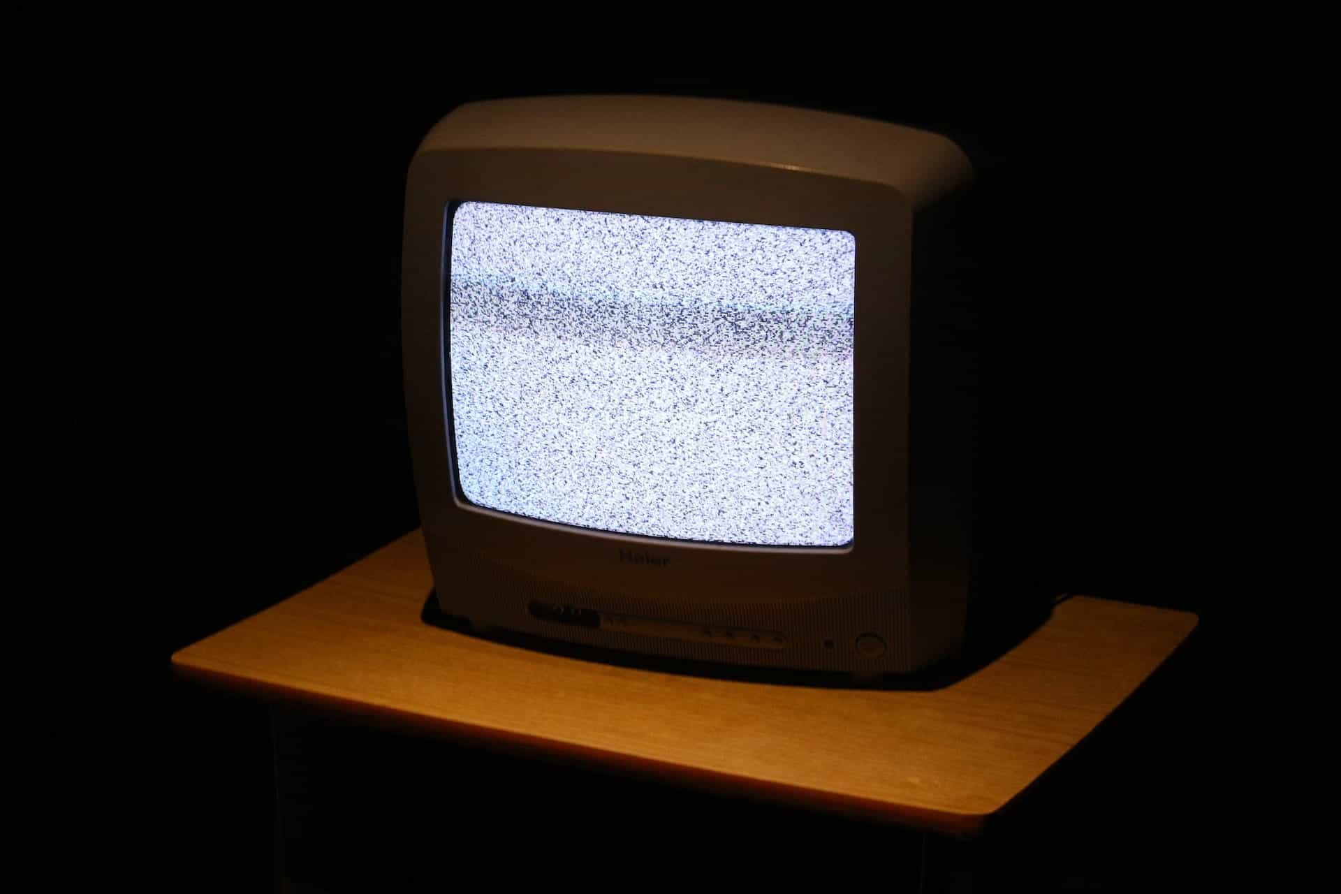 An old-fashioned CRT television with static on the screen.