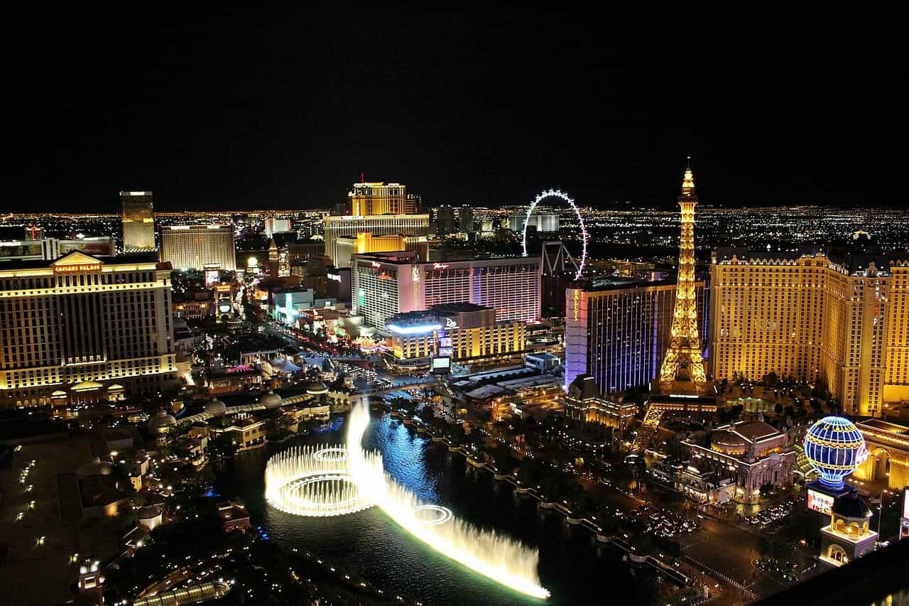 The world-famous “Strip” in downtown Las Vegas, Nevada, featuring dozens of hotels and casino resorts, a Ferris wheel, a mock Eiffel Tower, and a large fountain.