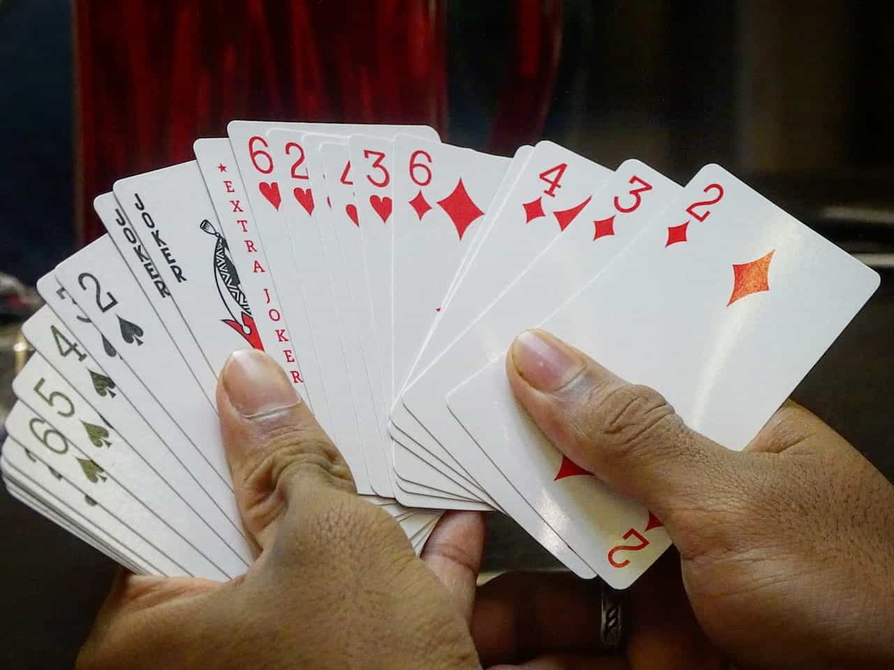 Hands holding a deck of cards.