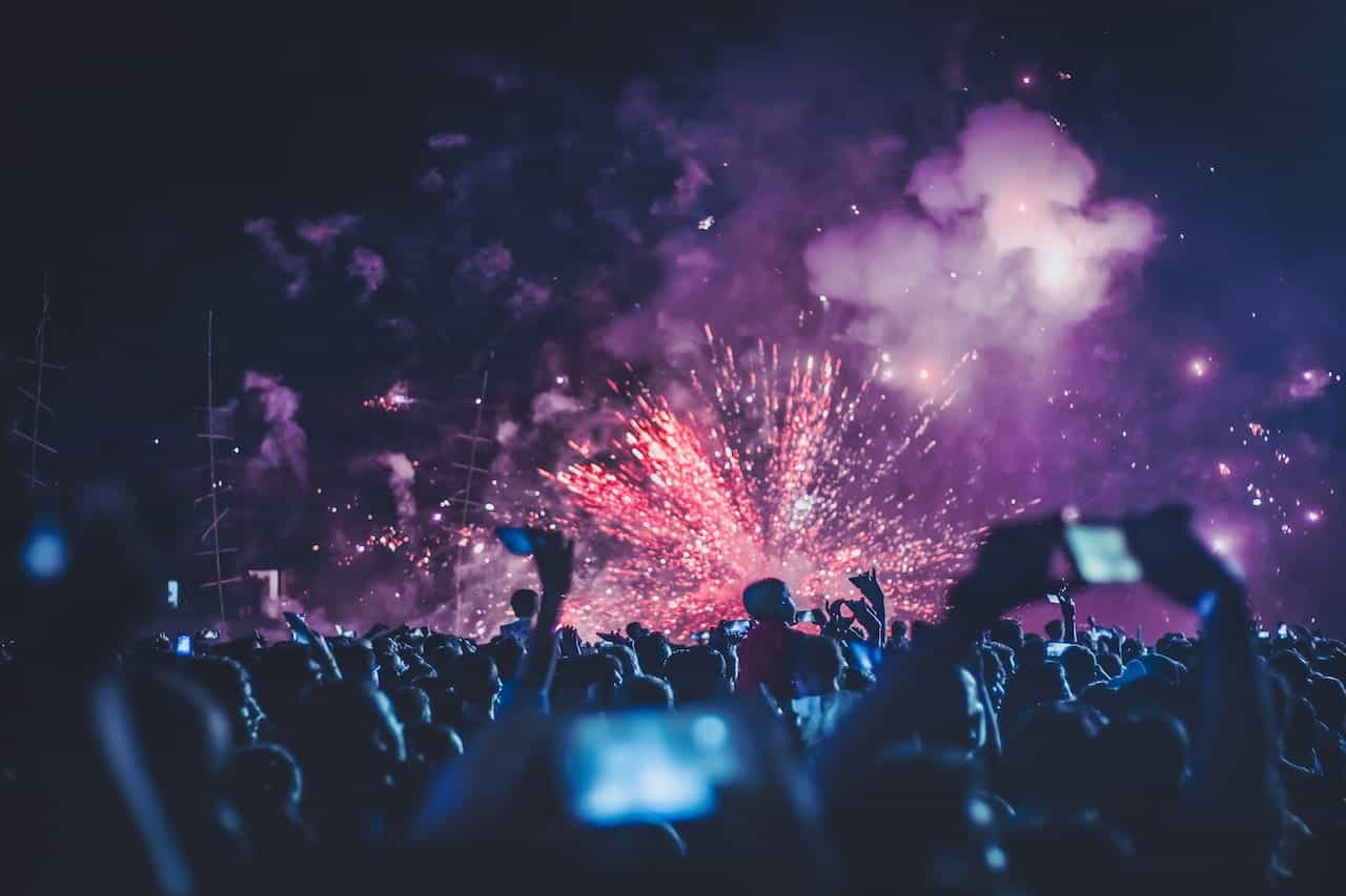 People watching a concert with fireworks.
