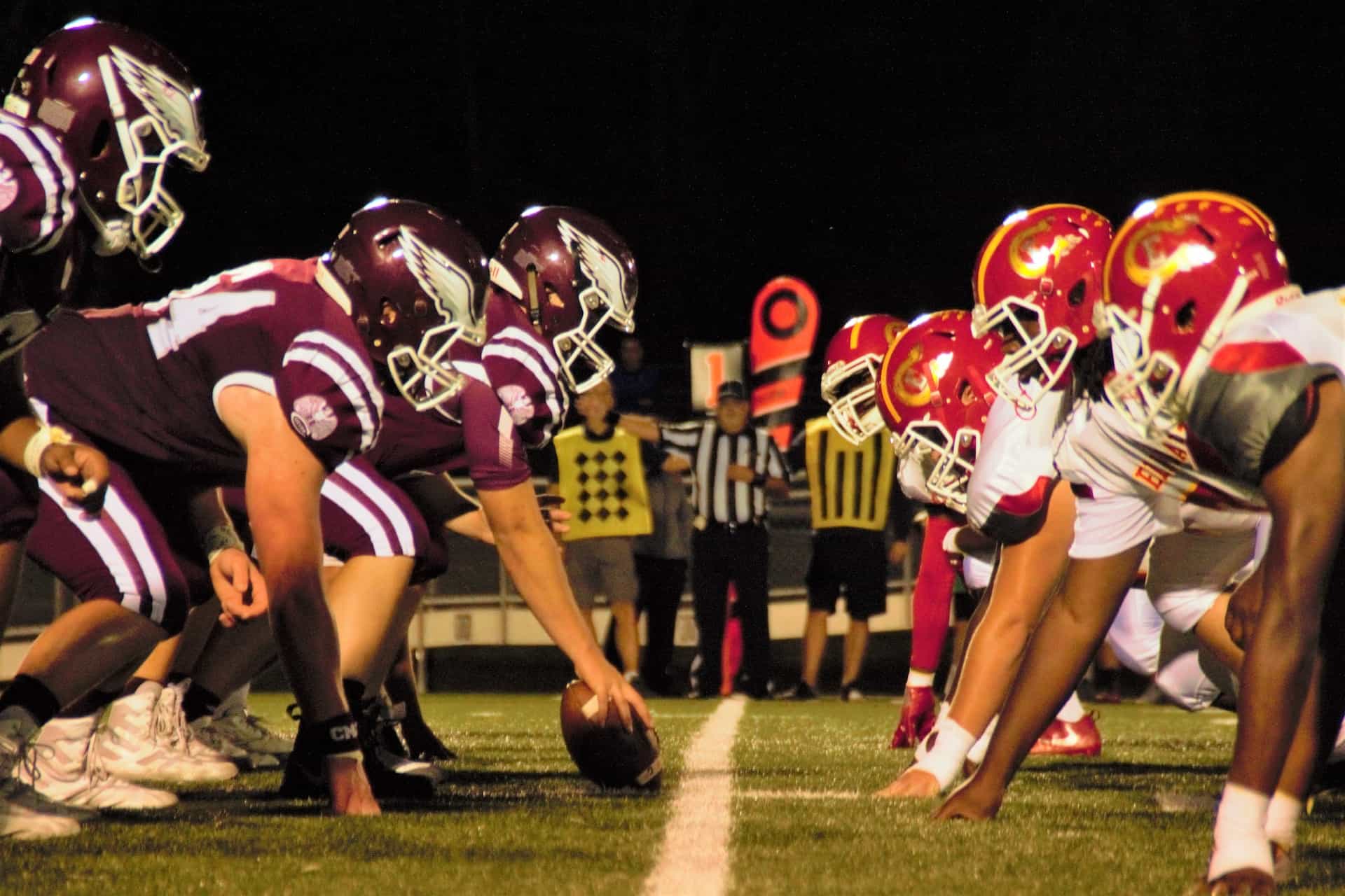 Two rows of American football players from opposing teams facing off against each other at the start of a match.