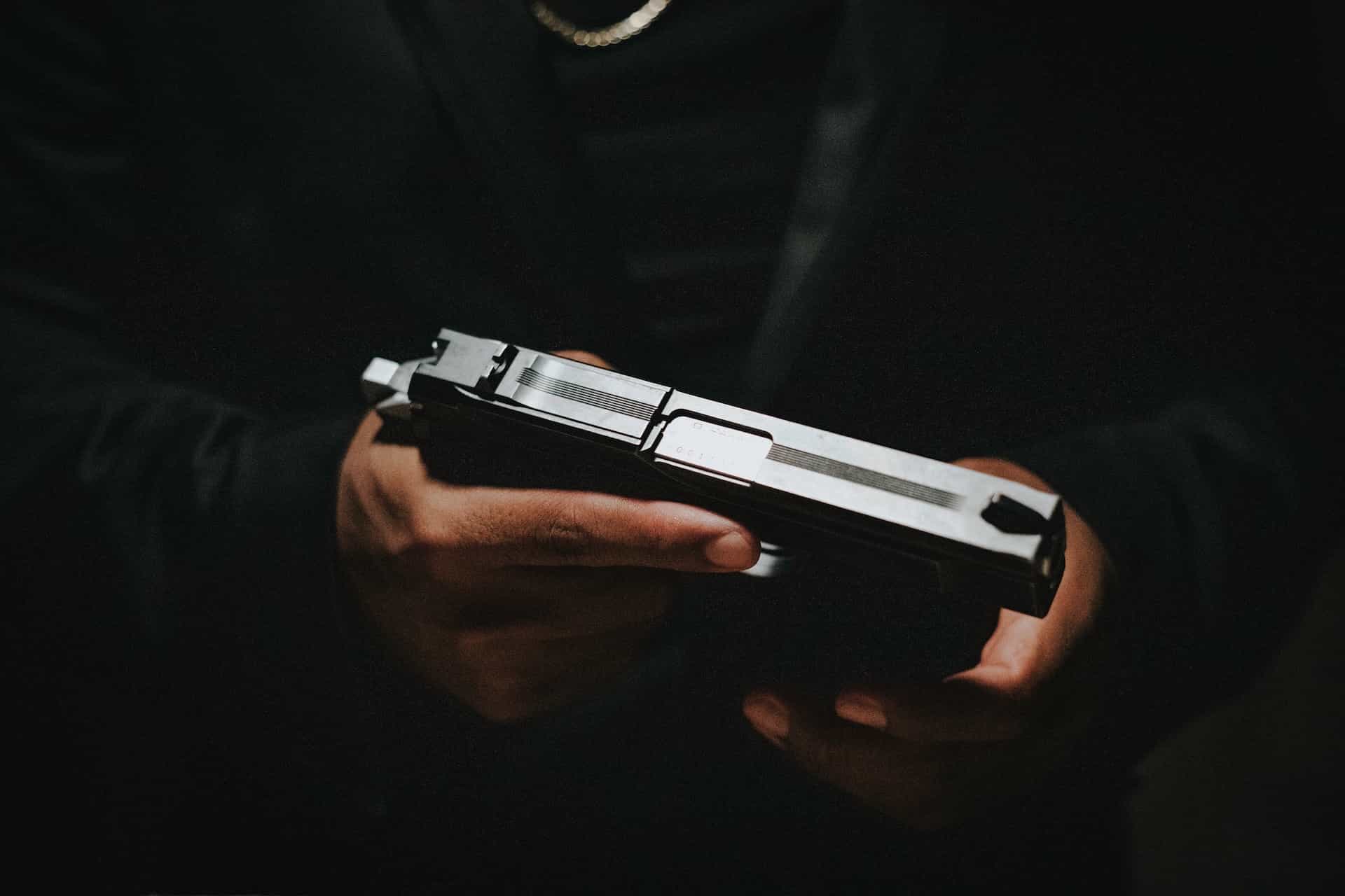 Hands hold a gun.