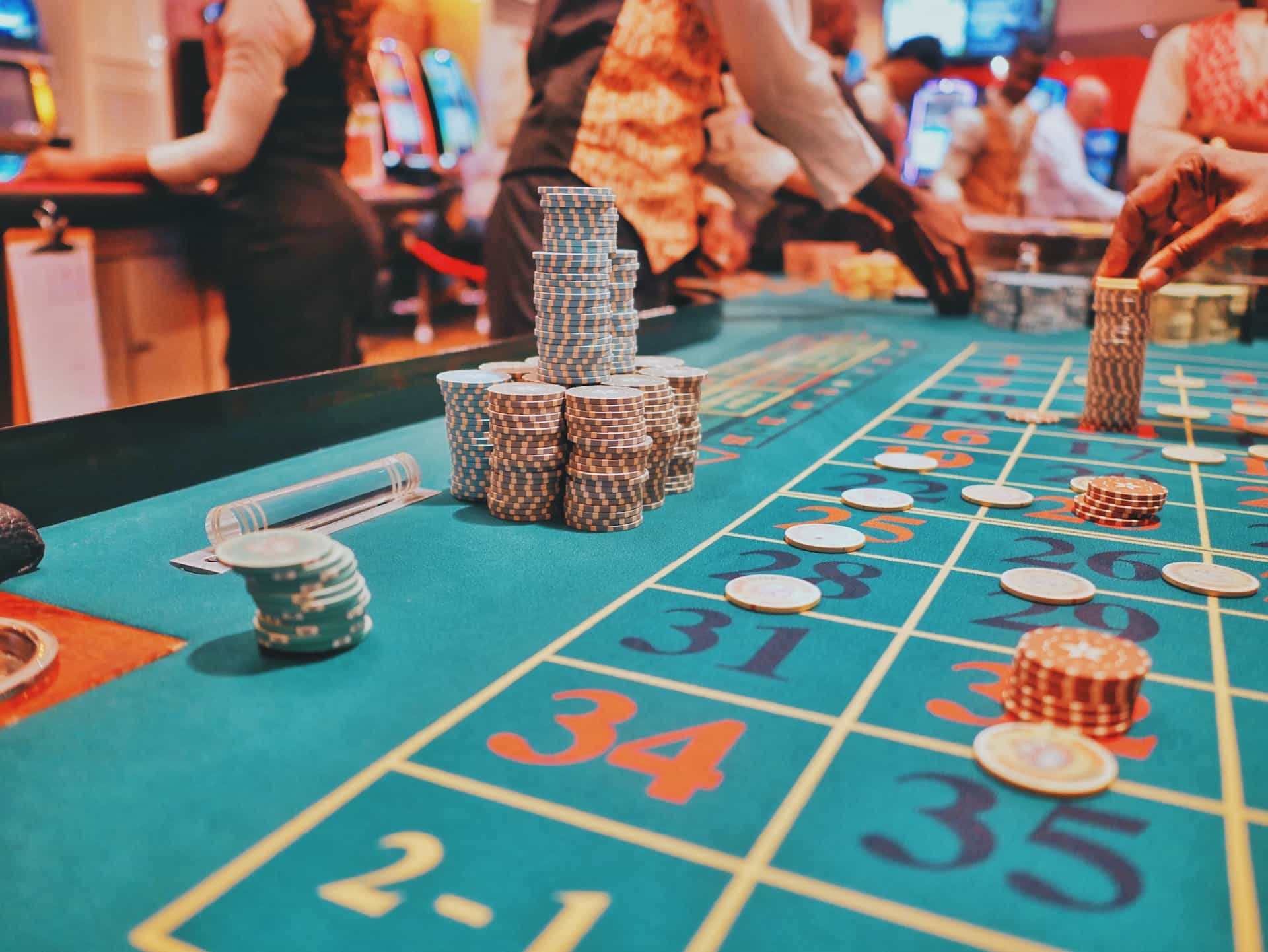 Various stacks of poker chips placed on a roulette table at a physical retail casino location.