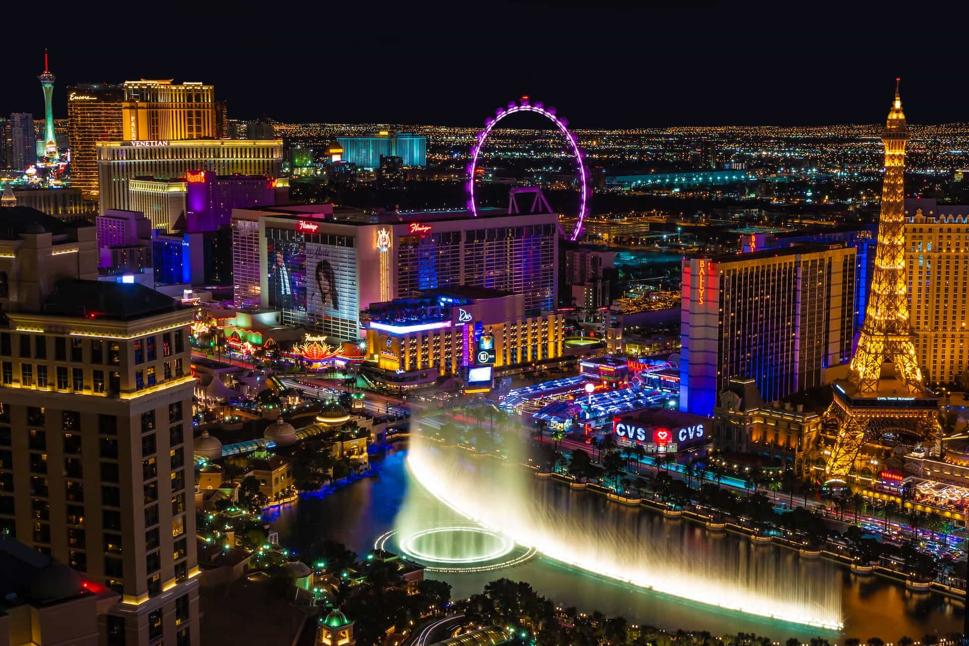 The world-famous Las Vegas strip in Nevada, showcasing countless casino and hotel resorts, as well as a replica Eiffel Tower and large ferris wheel.