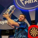 Luke Humphries lifts his 2023 World Grand Prix winner’s trophy.